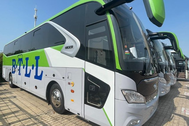 A white and green B.T.L.L. Higer bus parked outside