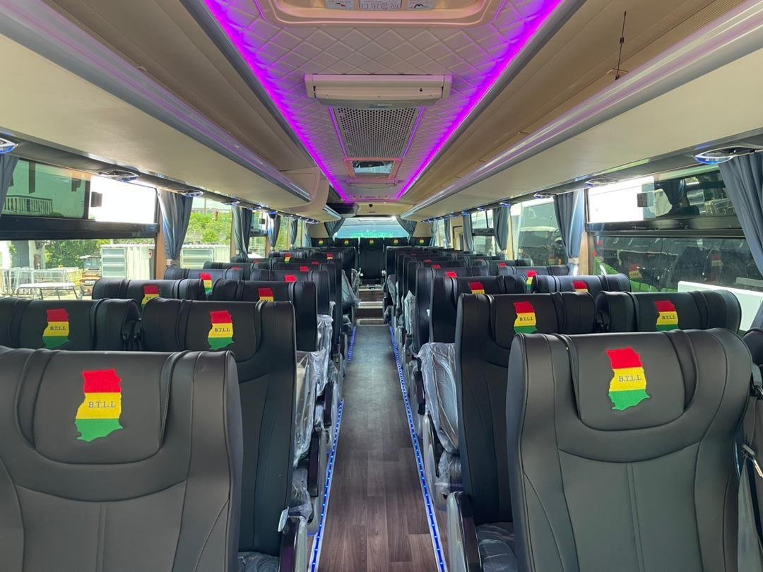 Inside a B.T.L.L. bus with ambient lighting and rows of cushioned seats